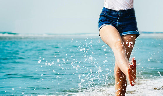 A woman playing around in the ocean on a Summer’s day.